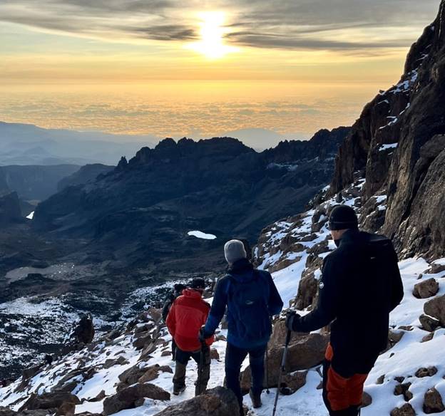 hiker celebrating finally seeing the peaks of Mount Kenya on hike