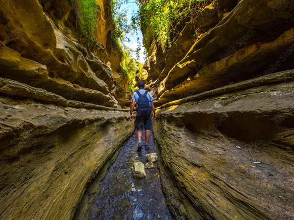 Tourists walking through a deep narrow path of the Hell’s Gate National Park gorges in Kenya