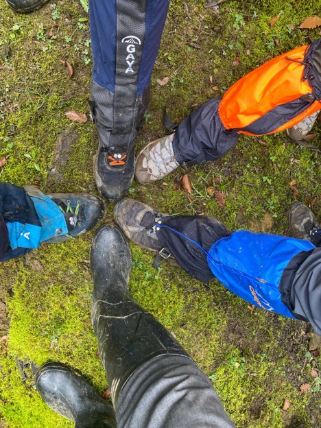 the legs of hikers showing their footwear, hiking boots, gaiters, rubber boots, and hiking pants. 