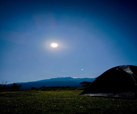 A black camping tent set up outdoor, late afternoon on Mount Kenya