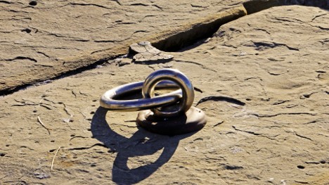 Metal climbing anchors attached to rock used by technical climbers on mountaineering expeditions 
