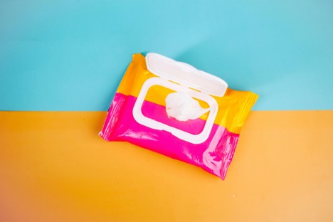 A packet of wet wipes on a blue and orange background