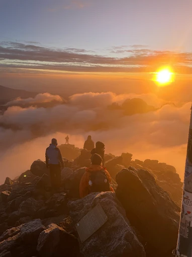 Hikers watching the sunrise on Pt Lenana Mount Kenya, after a successful climb