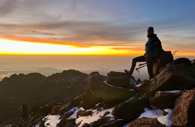 A hiker on Pt. Lenana Mount Kenya posing and enjoying the sunrise after a successful hike.