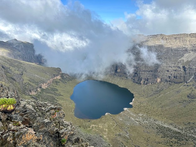 Lake Michaelson on Mount Kenya, Chogoria route, with low-lying clouds above the water and valley