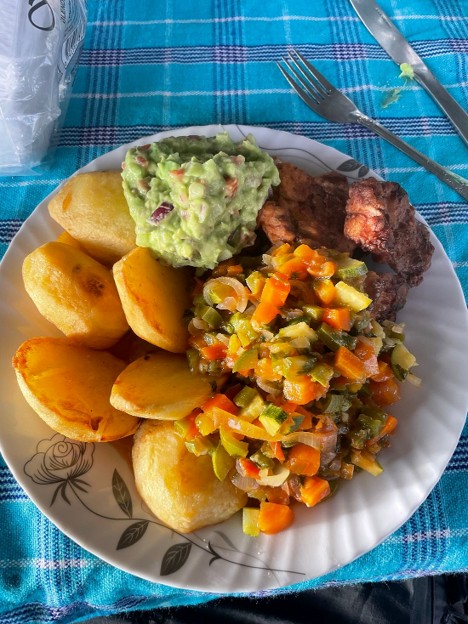 A plate of prepared food: meat, potatoes and avocado salad, for hikers trekking Mount Kenya